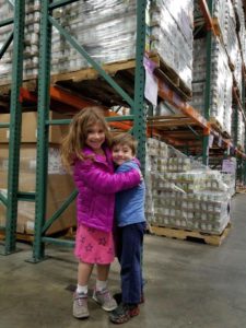 two young children hugging in warehouse