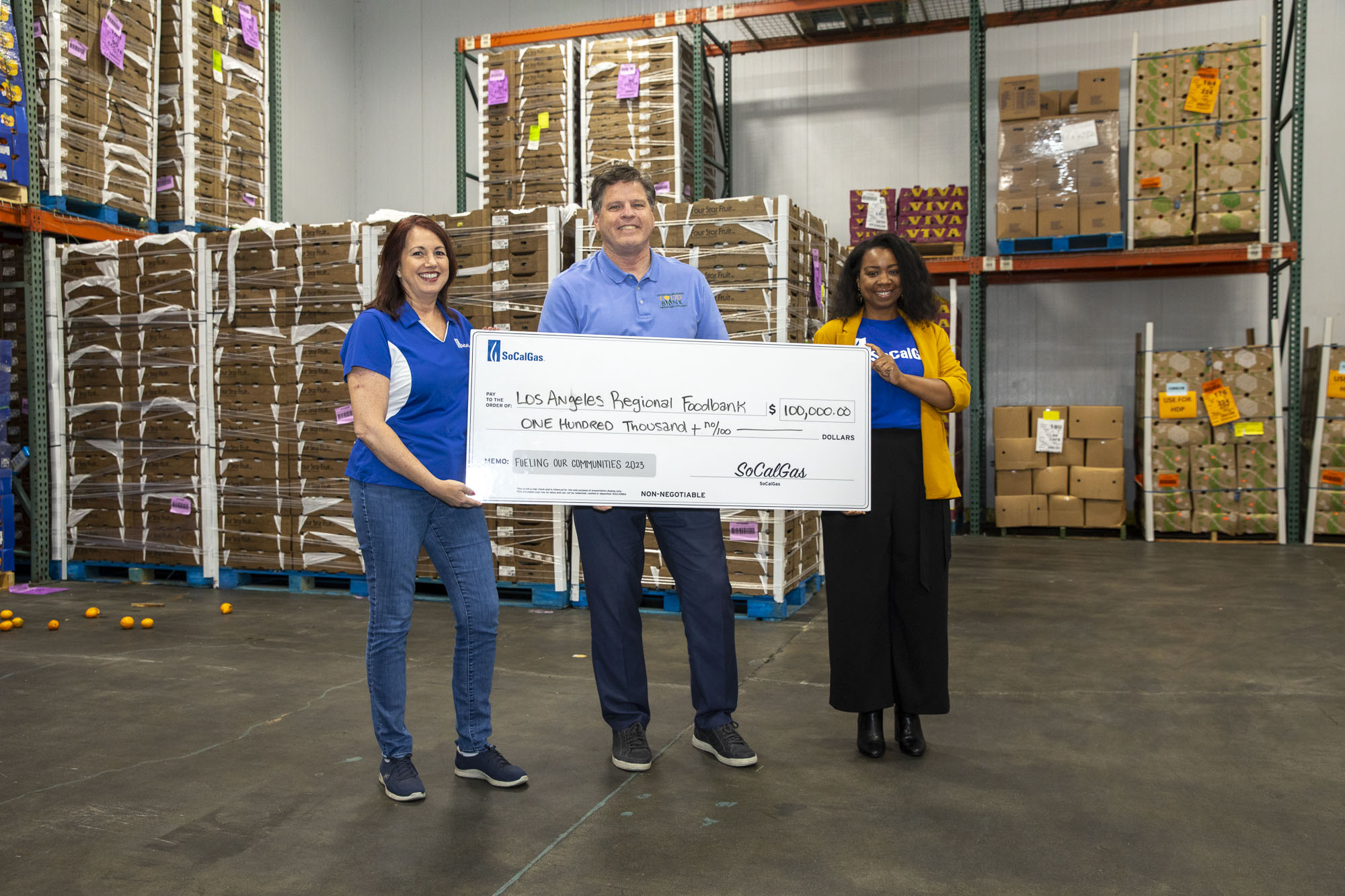 230707-SoCalGas-5818 Michael Flood holding a check with two SoCal Gas employees