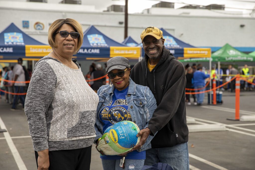 Lay Salter and his family holding a turkey at a food distribution in Long Beach.