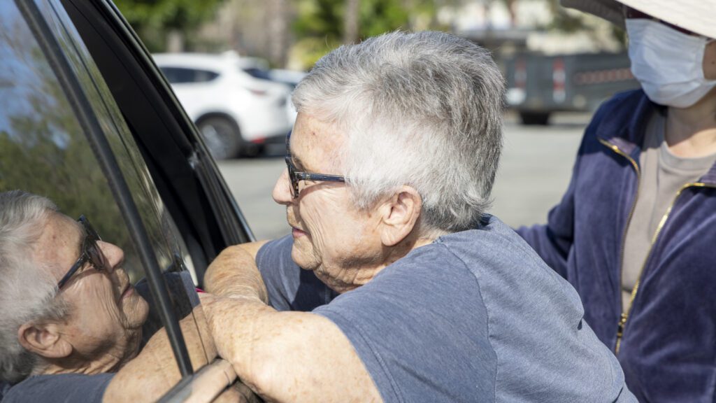 Vivian, volunteer at PazNaz talks to a food recipient at their drive-through distribution.