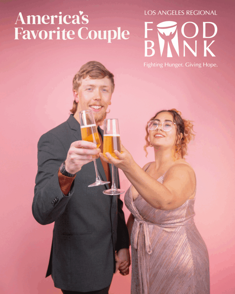 A smiling couple dressed formally clinks champagne glasses in front of a pink background with text that reads “America’s Favorite Couple” and highlights the Los Angeles Regional Food Bank: Fighting Hunger. Giving Hope.
