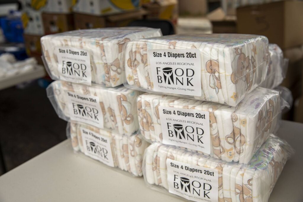 Six packs of size 4 diapers, each containing 20 diapers, are stacked on a table and labeled 